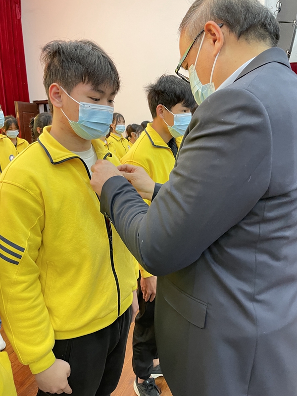 3.党委书记关意昭为新团员佩戴团徽.jpg